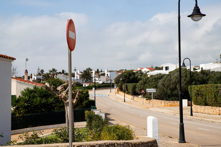 No Entry sign, a road with signs runs through a residential area with white houses Menorca Spainの写真素材