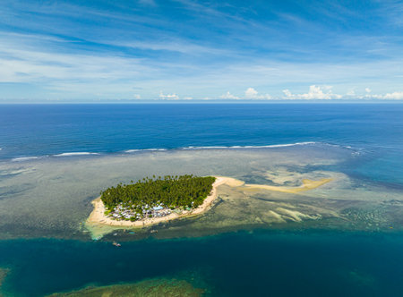Tropical island with white sand in coastline. Coral reefs in turquoise water with waves. Mindanao, Philippines. Summer and travel concept.の写真素材