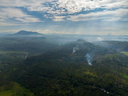 Mountain slopes with rainforest and a mountain valley with farmland. Mindanao, Philippines.の写真素材