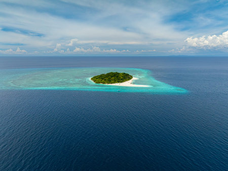 Mantigue Island covered in lush tropical trees. Camiguin, Philippines.