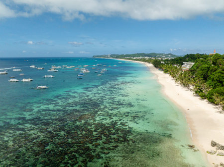 Tropical white sandy beach and transparent turquoise sea water with boats. Boracay, Philippines.