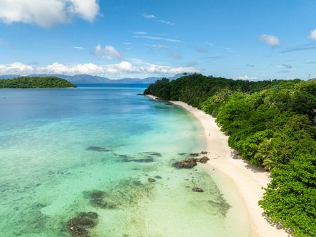 Flying over the Tiamban Beach with clear ocean waves on white sandy beach. Romblon Island. Romblon,...