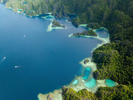 Lagoons with turquoise clear water and corals. Tour boats on blue sea. Coron, Palawan. Philippines.
