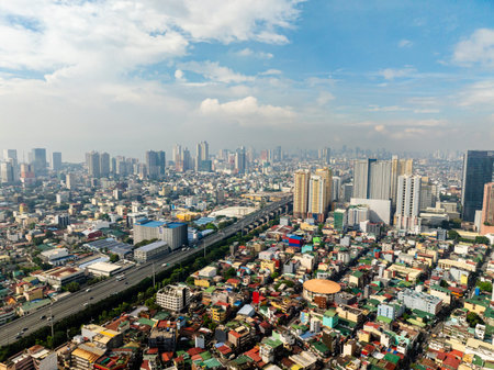 Highway with vehicles. Highrise buildings and residential area. Metro Manila, Philippines.