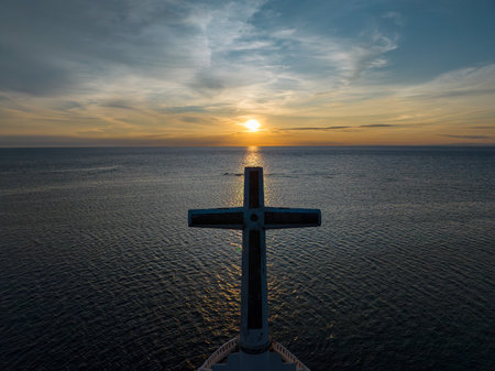 A large cross in the sea with sunset background. Sunken Cemetery in Camiguin Island. Philippines.の写真素材