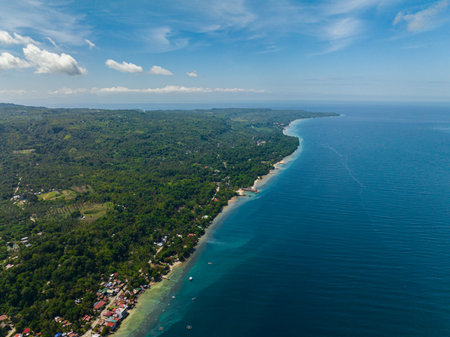 Tropical island with greenery forest and blue sea. Blue sky and clouds. Samal Island. Davao, Philippines.の写真素材