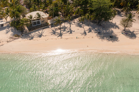 Sunlight over the sandy beach with crystal clear water and coconut trees. Bantayan Island, Cebu, Philippines.の写真素材