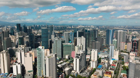 Aerial view of modern skyscrapers with blue skies and urban sprawl. Metro Manila, Philippines.