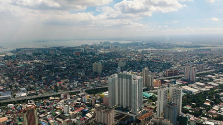 Urban skyline with dense buildings and ocean visible in the distance. Metro Manila, Philippines.の写真素材