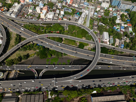 Aerial view of a complex highway network running through dense neighborhoods with some greenery....