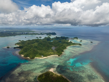 Green forest coastline with sandy beach and shallow reef near blue open sea. Siargao, Philippines. Sugba Blue Lagoon.の写真素材