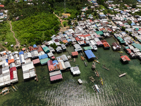 Clustered stilt houses with colorful roofs and small boats moored by the shore. Siargao, Philippines.の写真素材