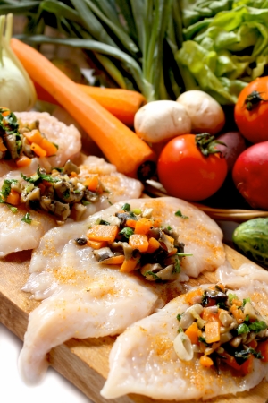 raw chicken breast filled with chopped mushrooms,greens, onion and carrots garnishの写真素材