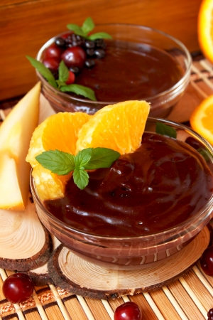 bowls of chocolate pudding with berrie fruits,orange slices and mint leaves, sweet dessertの写真素材