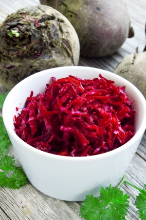 bowl of raw grated beet with parsley leavesの写真素材