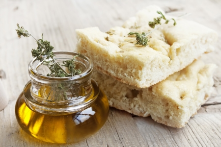 Focaccia italian bread slices with olive oil bottle placed over wooden tableの写真素材