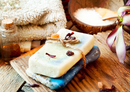 Spa Setting with Natural Soap, Essence Bottles, Towel, Sea Salt and Flower