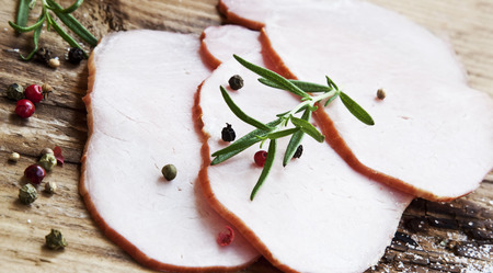 Pork Ham Fillet with Rosemary, Peppercorns, Garlic and Salt on Wooden Backgroundの写真素材