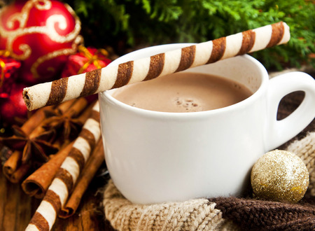 Hot Chocolate Cup with Spiral Snacks and Christmas Decoration in the Backgroundの写真素材