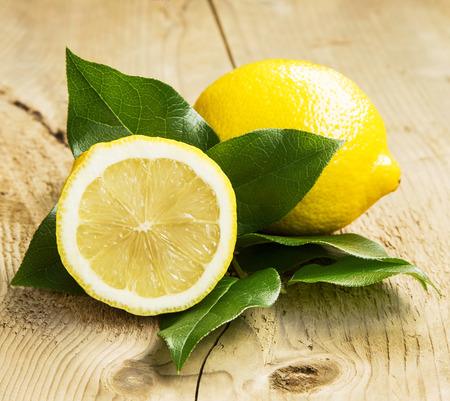 Healthy Lemon Fruit with Leaves on Wooden Backgroundの写真素材