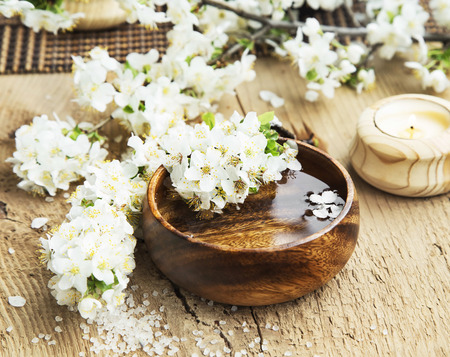 Spa Setting with White Flower Blossom in a Wooden Water Bowl and Sea Saltの写真素材
