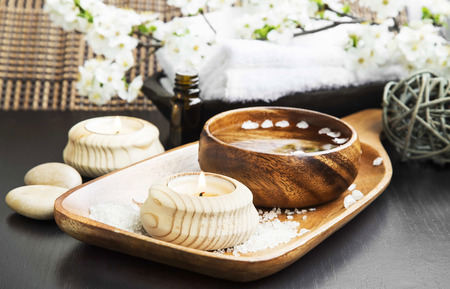 Spa and Wellness Setting with Candle, Water Bowl and Spring Flower Blossom Branch in the Backgroundの写真素材