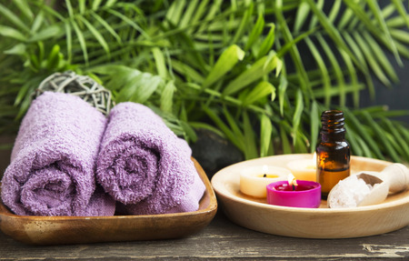 Spa.Scented Candles, Essential Oil Bottle and Cotton Towels on Green Wellness Backgroundの写真素材