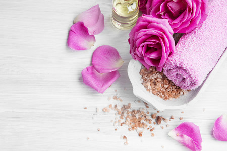 Spa setting with rose pink flowers and petals,bath salt and body-oilの写真素材