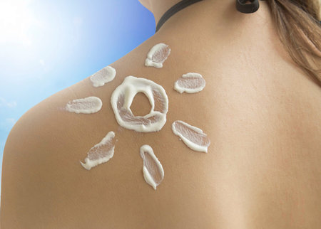 Female shoulder with sunscreen cream for skin protection