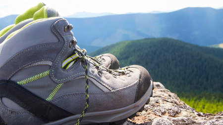 Pair of mountain hiking boots on the peak in nature