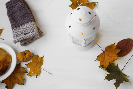 Autumn lantern with leaves and hand-warmers on white backgroundの写真素材