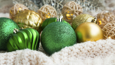 Festive green and golden Christmas balls on a woolen blanketの写真素材