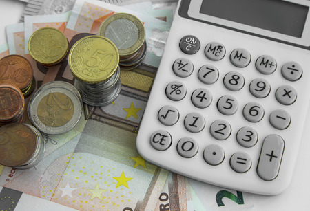Finance and accounting concept.Money coins and banknotes with calculatorの写真素材