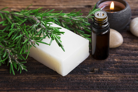 Rosemary soap and essential oil aromatherapy with candle on wooden backgroundの写真素材
