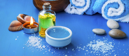 Spa setting with bath oil and face mask, bath salt and candleの写真素材