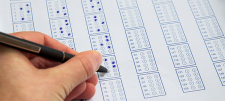 Filling exam questionnaire,hand with pen marking right answers at school or universityの写真素材