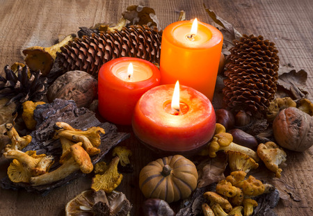 Fall candles decorations with dried leaves, pumpkins, chanterelle mushrooms, pine conesの写真素材