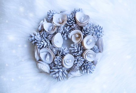 Festive blue Christmas wreath decorated with icy cones and wooden flowers on faux fur background, top view holiday winter decorationの写真素材