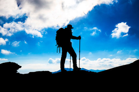 Hiker silhouette with backpack on mountain の写真素材