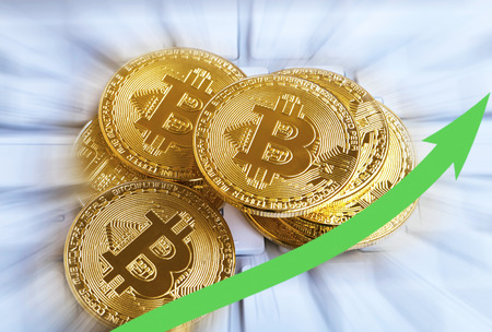 Pile of golden bitcoins with rising arrow.Decentralized virtual cypto currency growthの写真素材