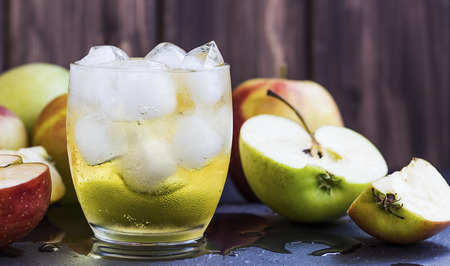 Fresh apple cider beverage with ice cubes and apples の写真素材