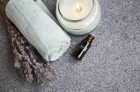 Spa still life with lavender oil and flowers, towel and candle, top view, spa settingの写真素材