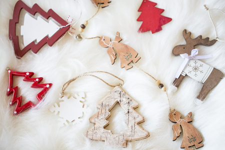 Festive wooden Christmas decorations on white faux fur, top viewの写真素材