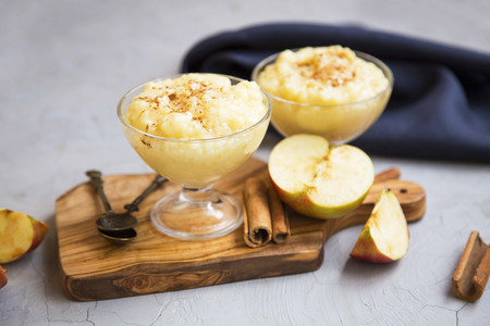 Rice milk pudding dessert in cups with cinnamon and applesの写真素材