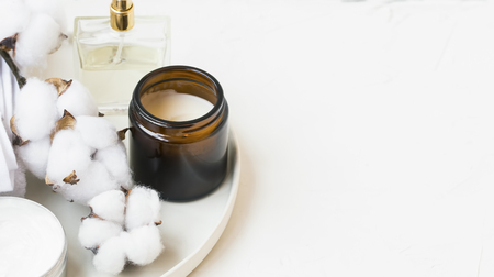 Spa still life setting with white cotton buds and towels, scented candle and perfume bottle, minimal interior still life and decorの写真素材