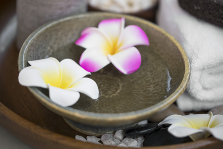 Spa still life with frangipani flowers in a bowl, spa and wellness treatments, natural spa detailsの写真素材