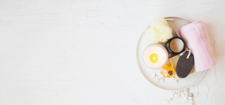 Top view of spa still life setting with natural products, white tray with towel, candle, oil, bath...