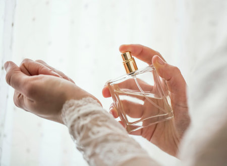Bride hands applying perfume on her wrist, closeup selective focus