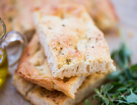 Foccacia bread closeup with olive oil and oregano herb, selective focus of freshly baked italian...