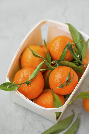 Fresh clementines citrus fruits in a basket, healthy organic clementines with leavesの写真素材